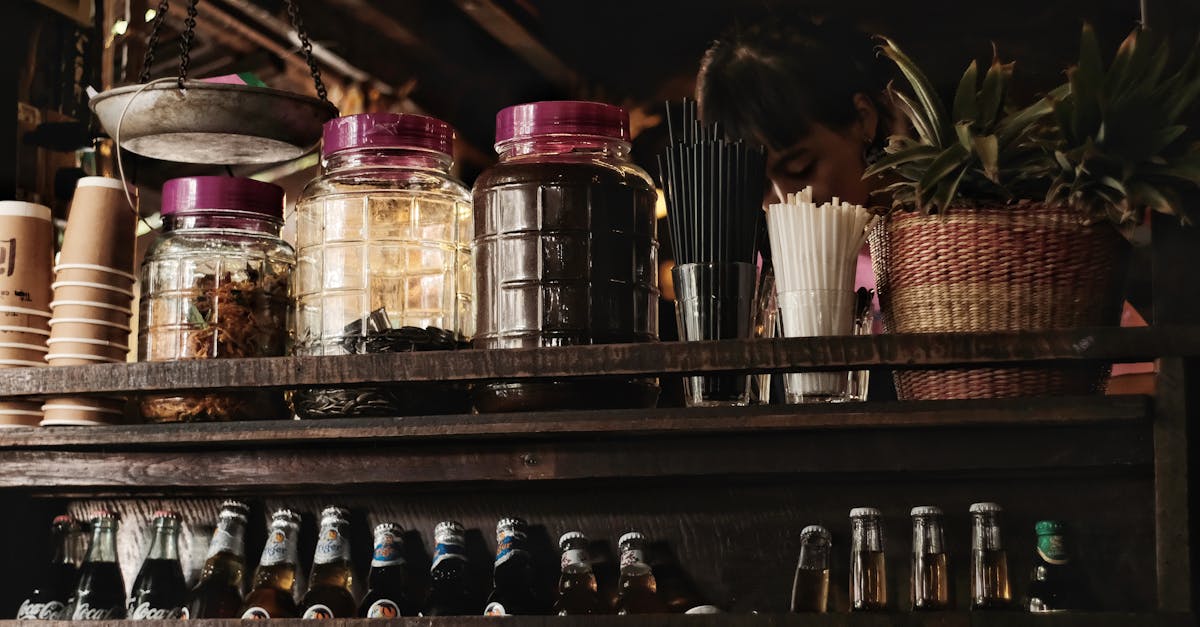 Rustic bar setup with glass jars, beer bottles, and a variety of drink accessories.