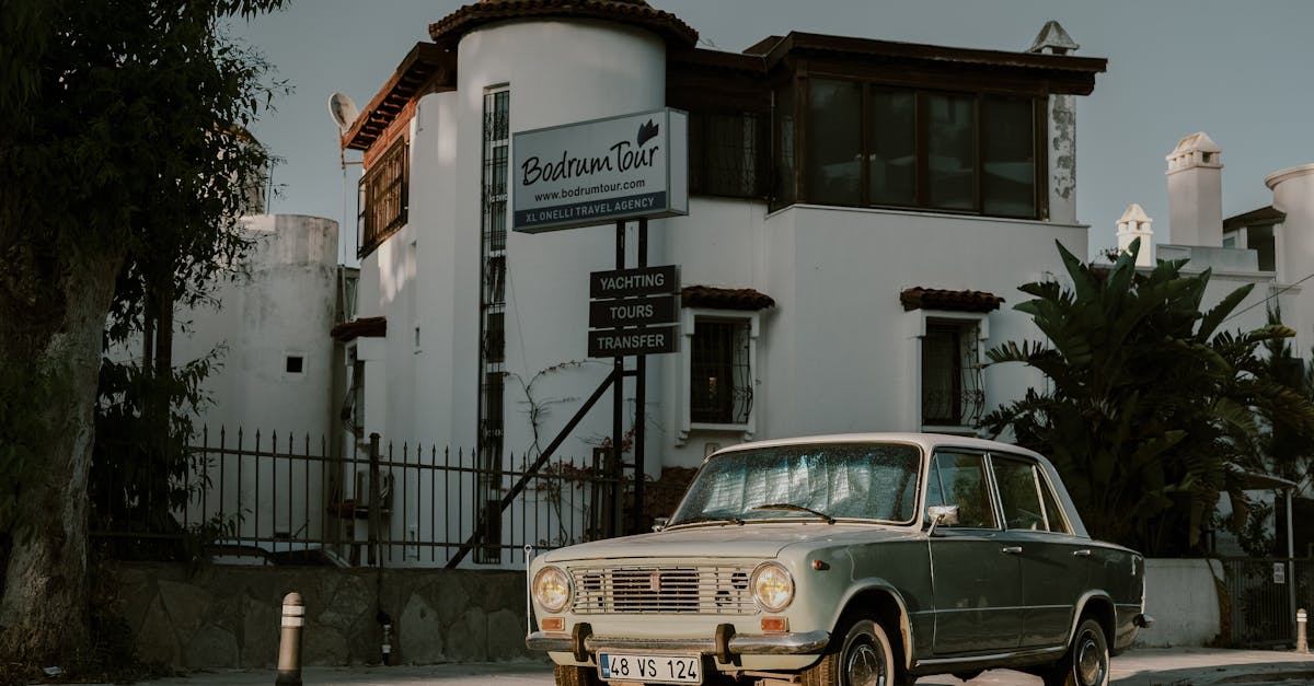 Classic vintage car parked outside Bodrum Tour Agency in Bodrum, Turkey, during daylight.